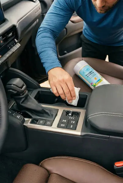 Man wiping down SUV with natural cleaning wipe