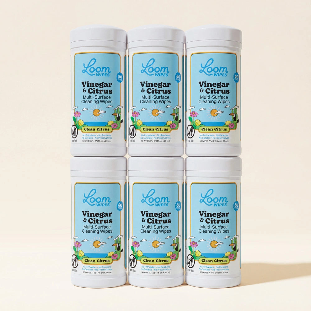 Six containers of Loom Vinegar & Citrus multi-surface cleaning wipes on a beige background