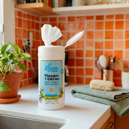 Loom Wipes vinegar and citrus cleaner container on a kitchen counter with a tiled backsplash